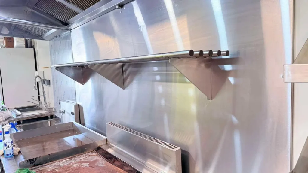 Degreased stainless steel splashback and work area in a commercial kitchen.