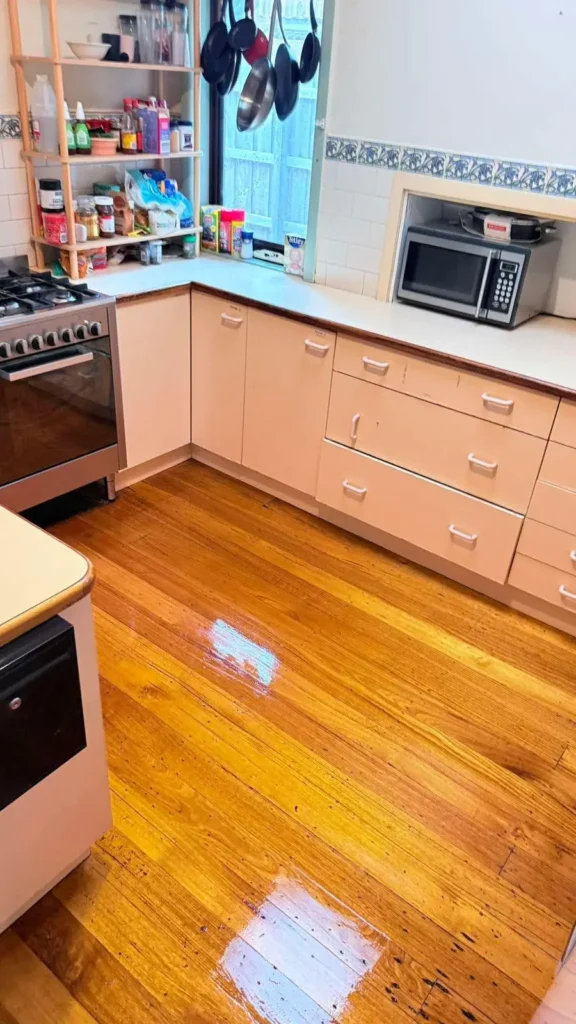 Professional kitchen deep cleaning with polished timber floors and sanitized surfaces.