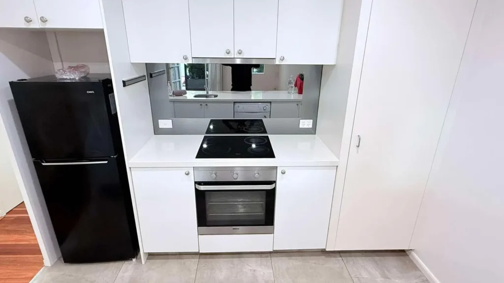 Freshly cleaned modern kitchen with polished surfaces, appliances, and tiled flooring.