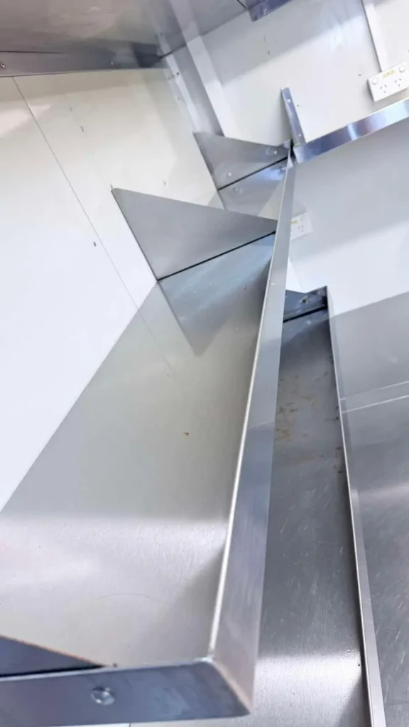 Commercial kitchen stainless steel shelving professionally cleaned and polished.